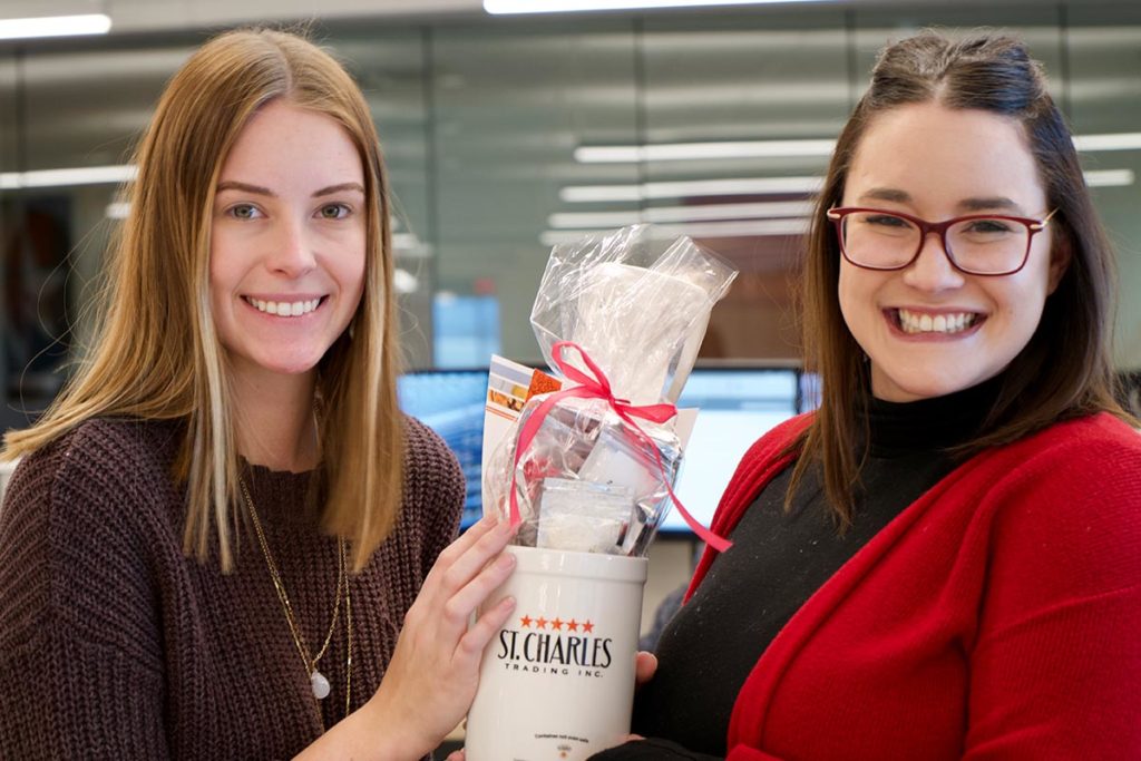 Two St. Charles Trading employees holding their Valentine's Day Gift Packages