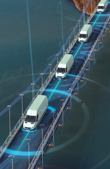 Small delivery trucks cross a bridge.