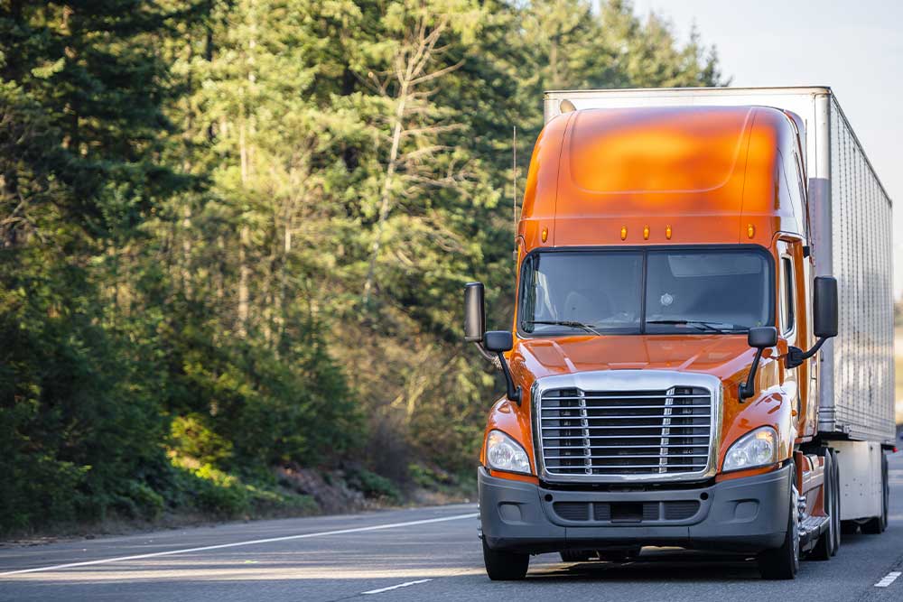 Driving down the road is an orange trailer.