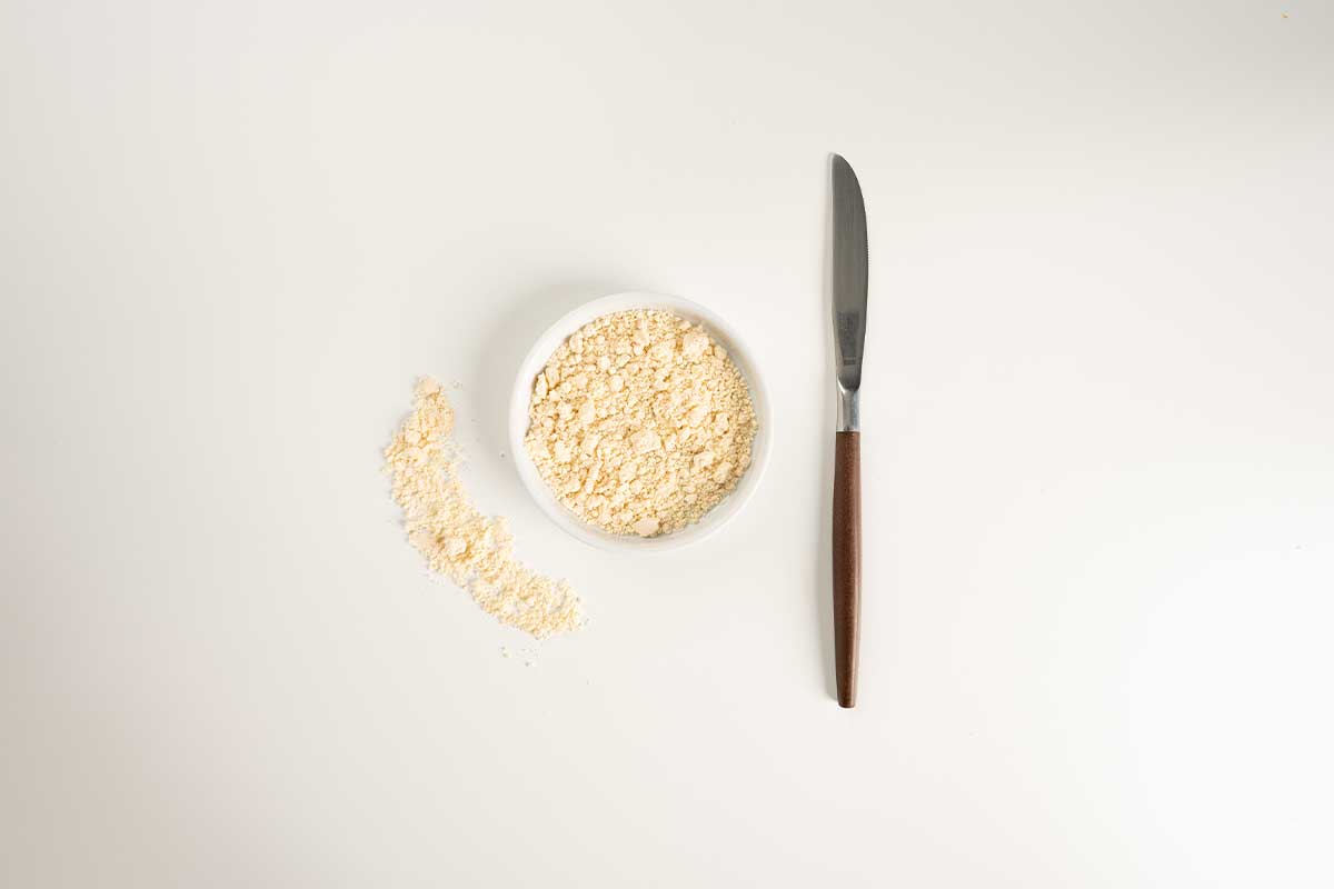 Original Powder in a white bowl with a butter knife on the right.