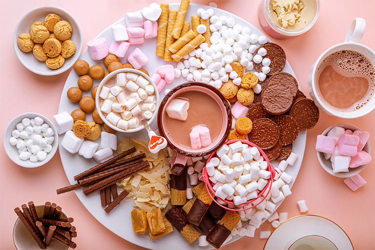 Charcuterie board with marshmallows and chocolate on a Valentine's theme.