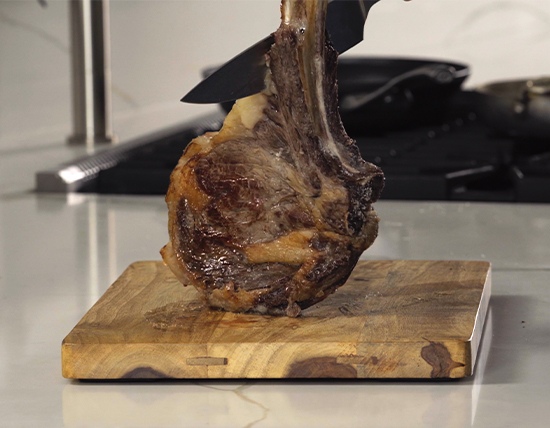 Tomahawk Steak on wood cutting board.