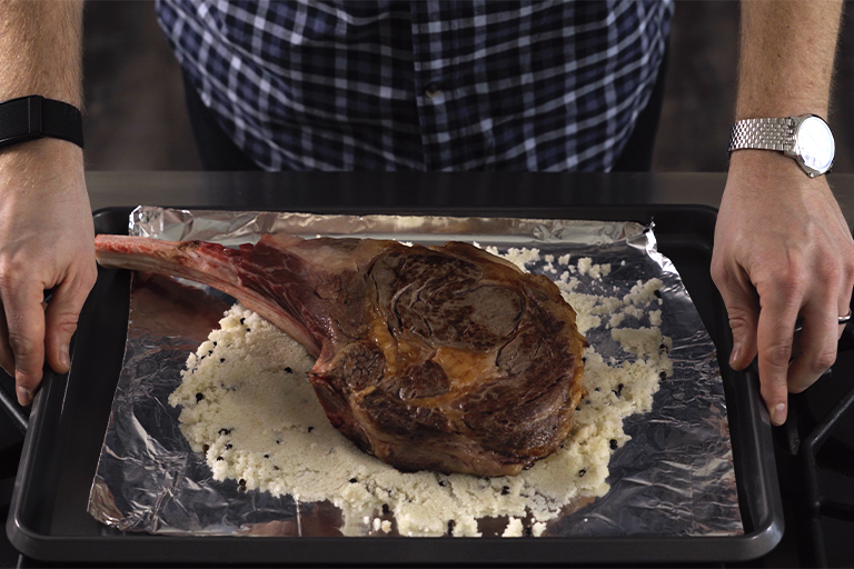 Tomahawk steak over salt and pepper mix