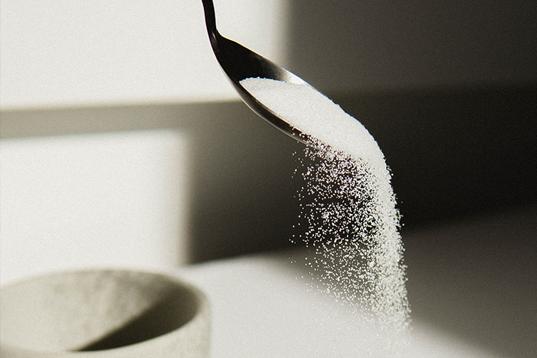 Sugar falling of a silver spoon