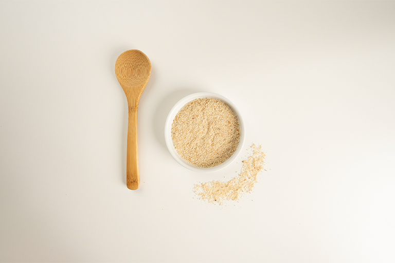 On the left, a breadcrumb-filled bowl and a wooden spoon.