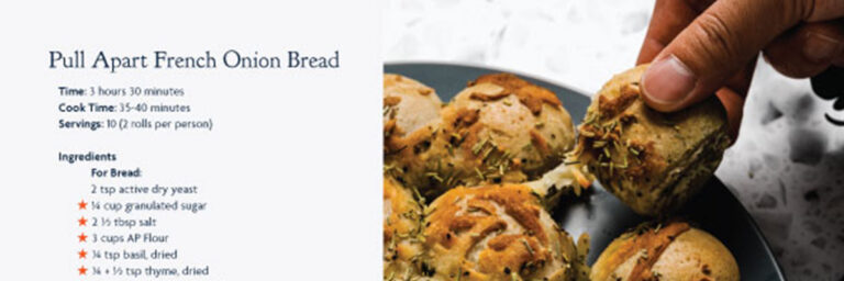 Pull Apart French Onion Bread recipe with an image of a hand pulling bread apart that is on a dark grey plate