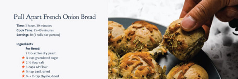 Pull Apart French Onion Bread recipe with an image of a hand pulling bread apart that is on a dark grey plate, featured in the measures cookbook