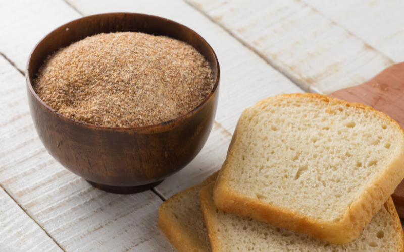 Breadcrumbs in a bowl, bread on side