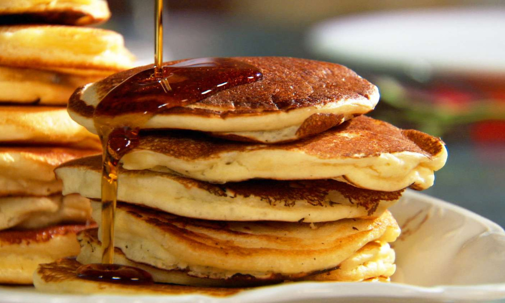 Adding coconut on delicious pancakes.