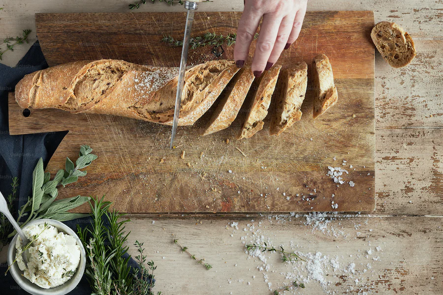 Baguette sliced on cutting board.