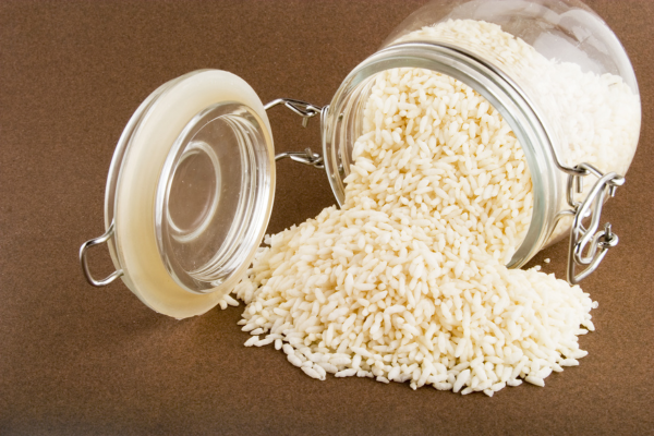 A photo of a tipped over jar of instant rice with the rice spilling out.