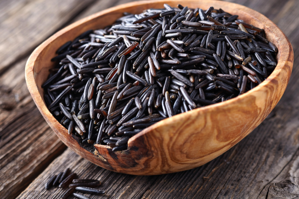 A photo of wild rice in a wooden bowl.