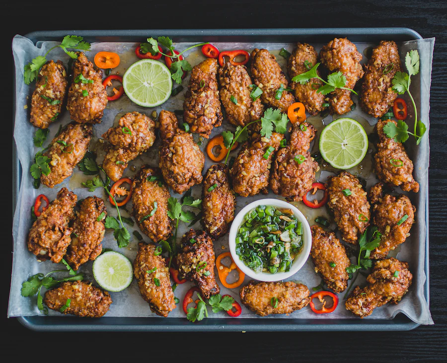 Tray of breaded chicken wings with garlic sauce.