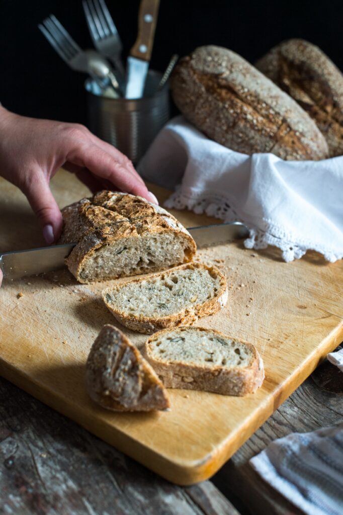 Cutting slices of bread on a board.