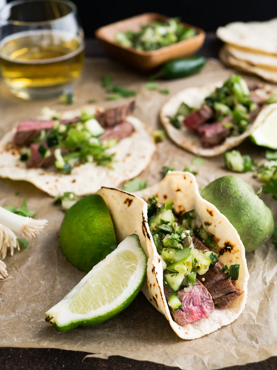 Steak tacos with lime and masa flour tortillas.