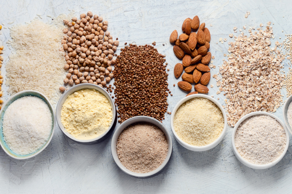 Gluten-Free ingredients in their own bowls, lined up, and slightly spinning on top of a white marble countertop