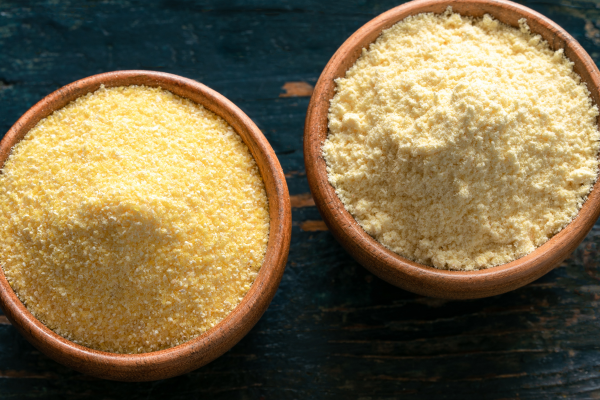Cornmeal and Cornflour showcased in their own wooden bowls on a dark countertop