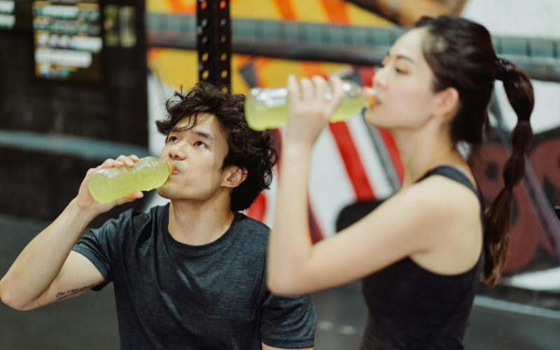 Two athletes drinking out a hydration beverage with premium ingredients