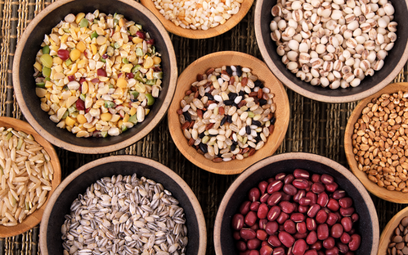 Ancient grains that support gut health in various wood bowls across a table