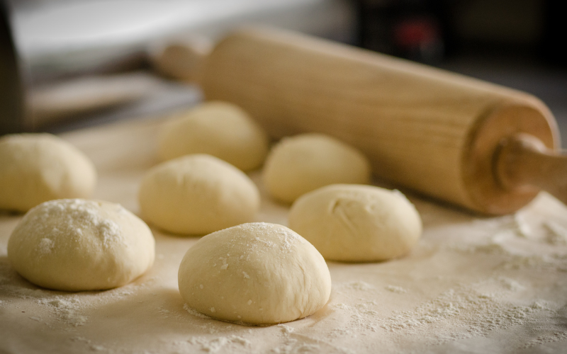 Rolling pin and dough rolls on a floured surface