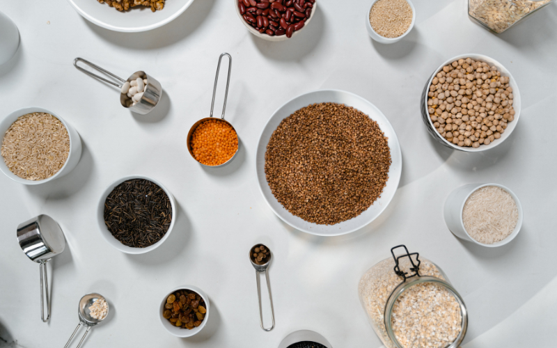 White background with Assorted Ingredients in Bowls, Jars and Measuring Cups