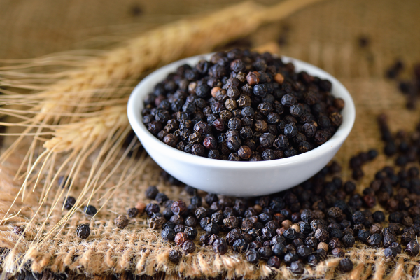 black pepper in white bowl on a table with tan cloth