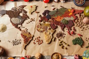 A world map made of spices and grains. The continents are made of different types of spices, such as cumin, coriander, and paprika.
